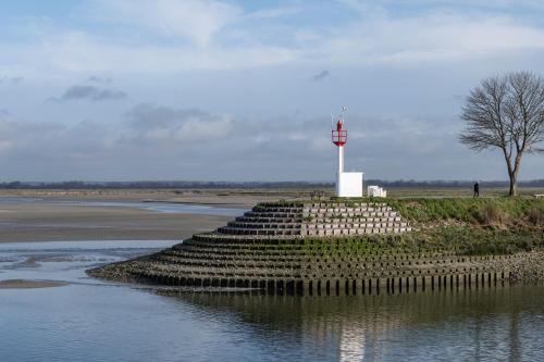 a lighthouse in the middle of a body of water at Gite des Gargouilles in Saint-Valery-sur-Somme