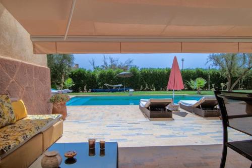 a patio with a couch and a pool at fleur de marrakech in Marrakesh