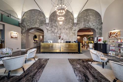 a lobby with a reception desk and chairs at Rivalta Hotel - Alfieri Collezione in Florence