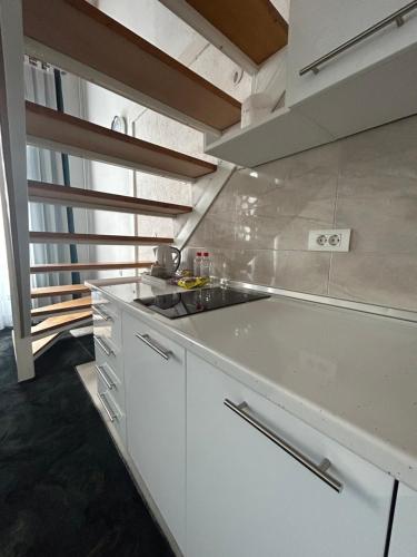 uma cozinha branca com um lavatório e um fogão em Latin Bridge Apartment Sarajevo em Sarajevo