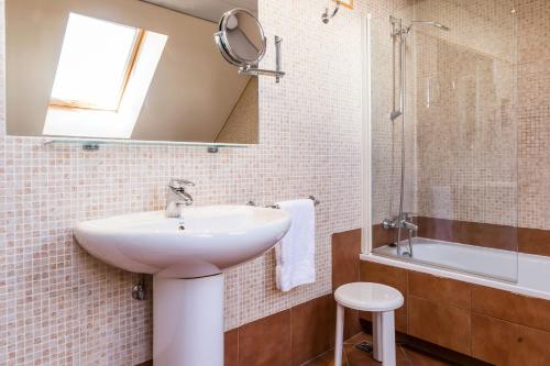 a bathroom with a sink and a mirror and a tub at Hotel Grand Pas in Pas de la Casa
