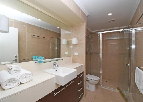 y baño con lavabo, ducha y aseo. en Oceanviews at Hervey Bay resort en Urangan