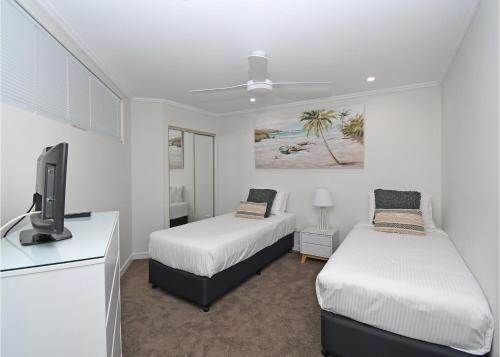 1 dormitorio con 2 camas, TV y tvoard en Oceanviews at Hervey Bay resort en Urangan