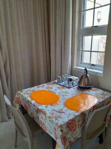 a table with two orange plates on top of it at Sugarbush Accommodation in Vereeniging