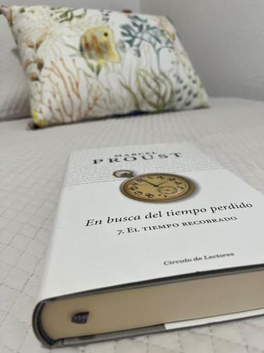 een boek op een bed bij En busca del tiempo perdido in Tavernes de la Valldigna