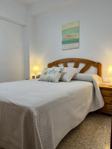 een slaapkamer met een groot bed met een houten hoofdeinde bij En busca del tiempo perdido in Tavernes de la Valldigna