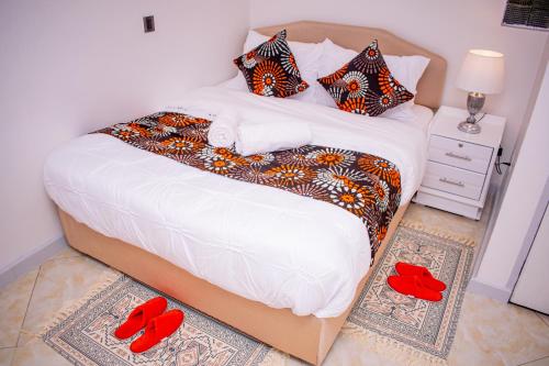 sypialnia z łóżkiem i czerwonymi kapciami na podłodze w obiekcie 17 Arabella Haven near Waterfront w mieście Karen