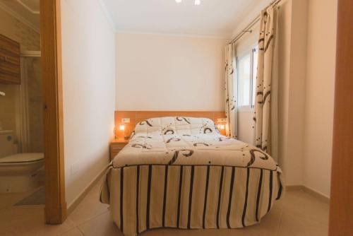 ein kleines Schlafzimmer mit einem Bett und einem WC in der Unterkunft 2-Bed Apartment with rooftop pool in Formentera de Segura