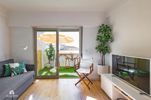 a living room with a couch and a tv at The Pateo Beach Apartment - Santa Cruz in Santa Cruz