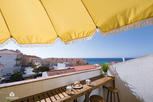 a table on a balcony with a view of the ocean at The Pateo Beach Apartment - Santa Cruz in Santa Cruz