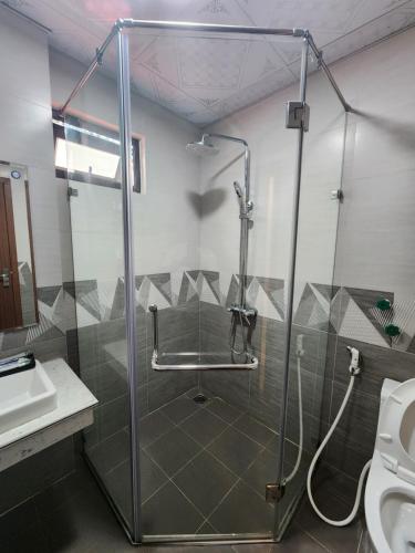 a bathroom with a shower and a sink at Tung Quang Hotel in Cat Ba