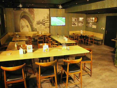 a restaurant with wooden tables and chairs and a screen at Mughal Suites in Ras al Khaimah