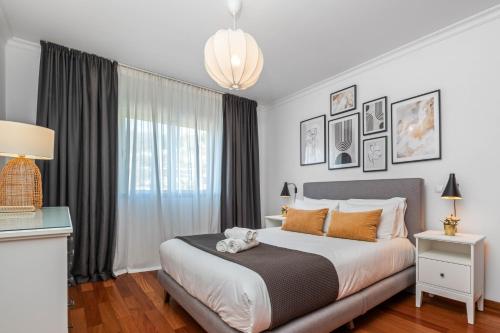 a bedroom with a bed with a teddy bear on it at Ficcus Home in Caniço