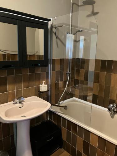 a bathroom with a sink and a bath tub at Bungalow Rochehaut au calme in Rochehaut