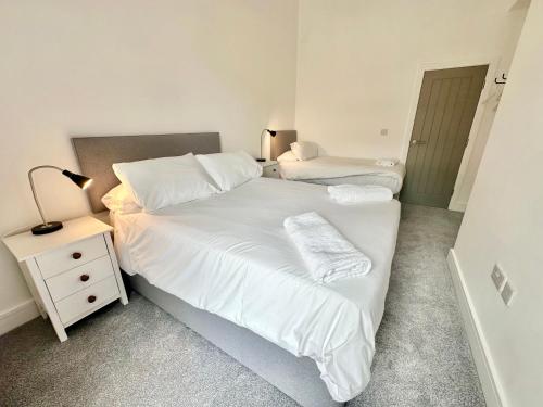 a bedroom with two beds and a night stand with a lamp at Fountain Apartment No 2 with Free Parking in York