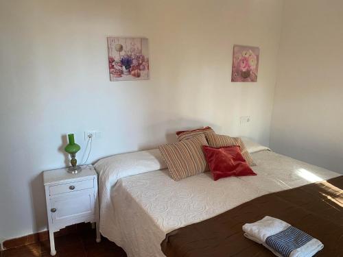 a small bedroom with a bed and a night stand at Apartamentos en sierra de gata ALMA in Villamiel
