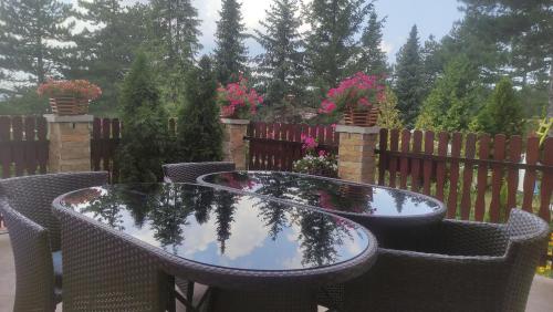 Una mesa y sillas con el reflejo de una valla. en Apartment Niva, en Zlatibor
