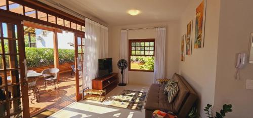 a living room with a couch and a balcony at Flat - SERRA E MAR - Paraty in Paraty