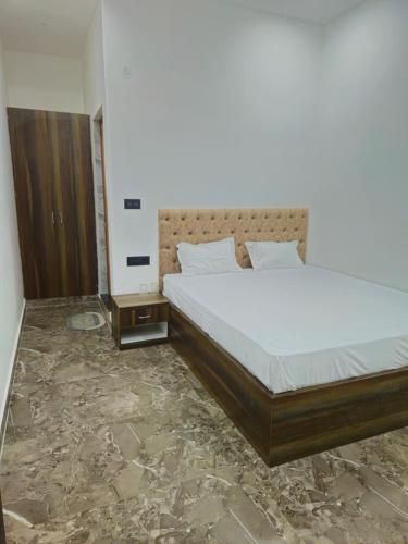 a bedroom with a large bed with a white mattress at Motel Ilika in Bilāspur