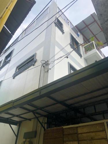 a white building with a balcony in front of it at Cozy Room, Study Space & Bathtub in Manila