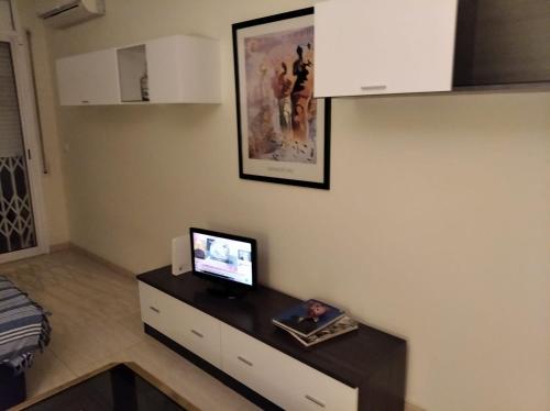 Habitación con escritorio y TV en la pared. en Isaac, en Figueres