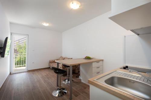 a kitchen with a table and a sink and a counter at Villa LANA*** in Omiš