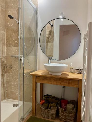 a bathroom with a sink and a shower with a mirror at Molinot Gîtes Nature & Confort in Alboussière