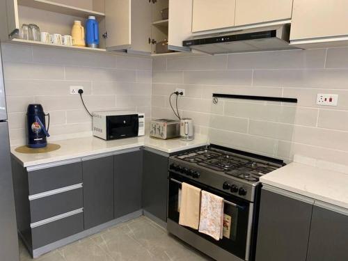 a kitchen with a stove and a counter top at Blissful Airport Serviced Apt. in Nairobi