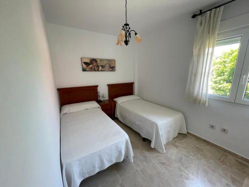 a bedroom with two beds and a window at Manilva Beach: Your Costa del Sol Getaway! in Castillo de Sabinillas