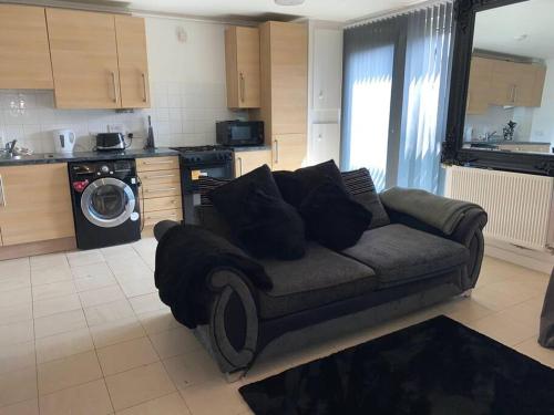 a living room with a couch in a kitchen at Comfort Luxe in Hatch End