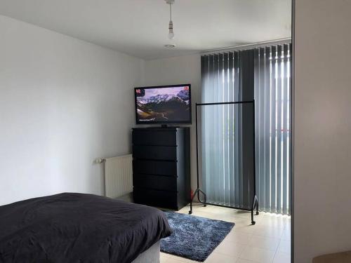 a bedroom with a bed and a flat screen tv at Comfort Luxe in Hatch End