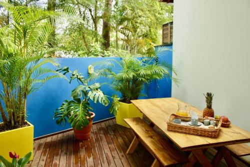 uma varanda com uma mesa de madeira e plantas em La Menina Mole Beachfront House! 4BR/4,5Baths em Florianópolis