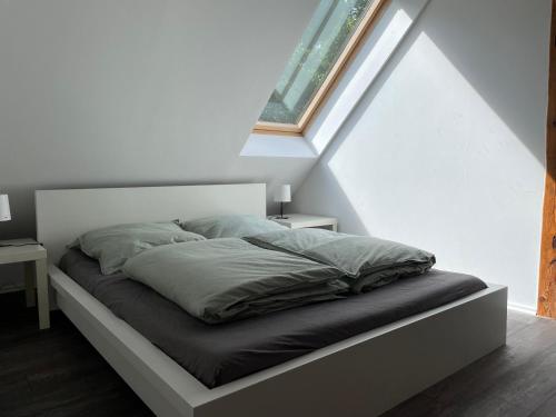 een bed in een witte kamer met een raam bij Landhaus im Bremischen in Hagen im Bremischen