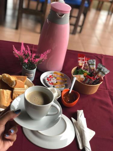 a table with a cup of coffee and a plate of food at Tahiti Hotel in Cotonou