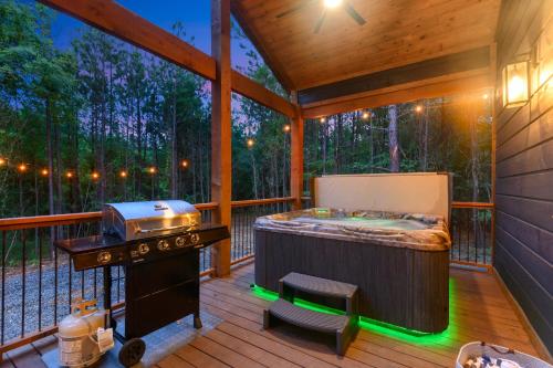 a screened in porch with a hot tub and a grill at Unwind in Style! *NEW* Sip and Stay Hideaway in Broken Bow