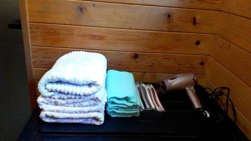 Ein paar Handtücher liegen auf einem Regal. in der Unterkunft BANRYU 萬龍 バンリュウ in Iida
