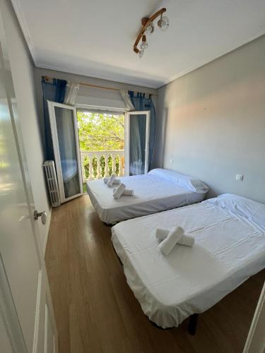 two beds in a room with a window at Villa Nogueroles in Sanchidrián