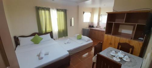 a small room with two beds and a television at CORALYN'S PLACE Family of 4 in Boracay