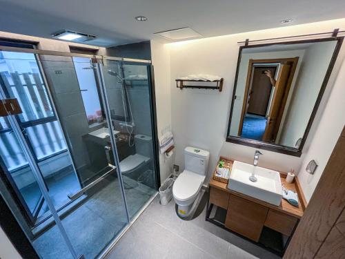 a bathroom with a shower and a toilet and a sink at Dalifornia Courtyard Retreat in Dali