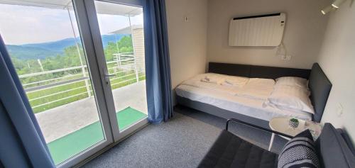 ein kleines Schlafzimmer mit einem Bett und einem Balkon in der Unterkunft Cer de munte in Nucşoara