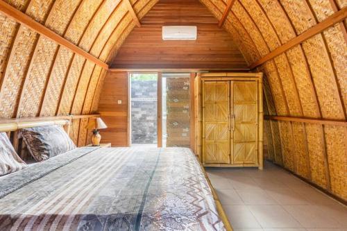 um quarto com uma cama num quarto de madeira em Djamezz Lumbung em Gili Air