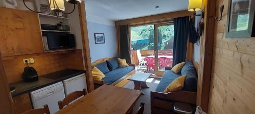 ein Wohnzimmer mit einem Sofa und einem Tisch in der Unterkunft CMD Méribel in Méribel
