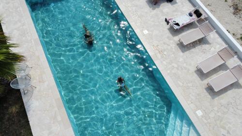 an overhead view of two people swimming in a swimming pool at Masseria Petrusella in Giuggianello