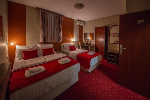 a hotel room with two beds and a bathroom at Hotel Bell in Leskovac