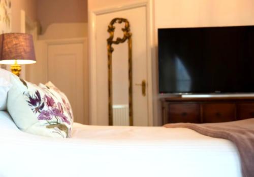 a bedroom with a bed with a flat screen tv at East Beach Hotel in Eastbourne