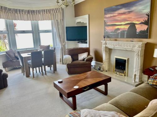 a living room with a fireplace and a dining room at Bayside - Breathtaking views of the Clyde in Rothesay