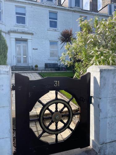 a black gate with a wheel in front of a house at Bayside - Breathtaking views of the Clyde in Rothesay