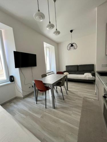 a living room with a table and chairs and a couch at Luxury apartment + garage in Trieste