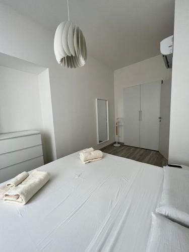 a large white bedroom with two towels on a bed at Luxury apartment + garage in Trieste