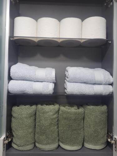 a closet filled with white towels and green socks at Brand New 2 Bedroom Apartment in Seoul